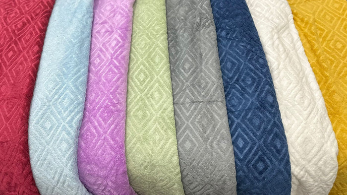 Row of textured fabric samples in various colors on a black background