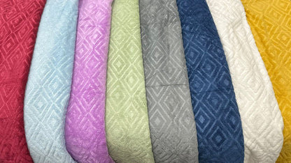 Row of textured fabric samples in various colors on a black background
