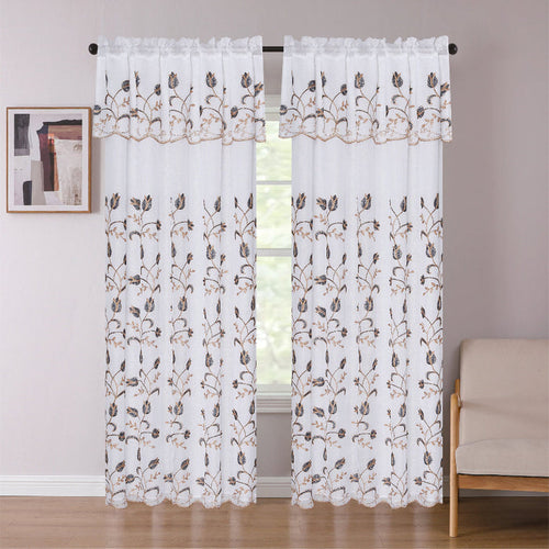 Sheer curtains with floral embroidery in a room with a window and beige sofa.