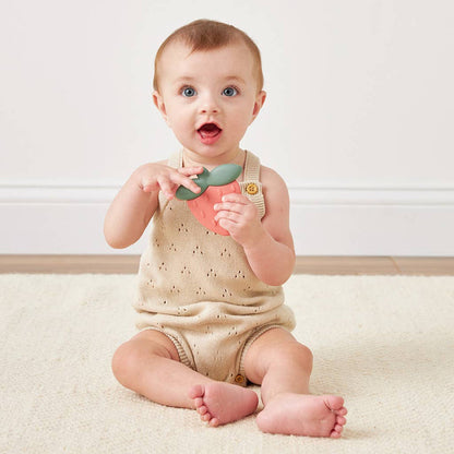 Baby playing with Slicone Teething Rattle Strawberry Sweetie Shake™ for soothing teething relief